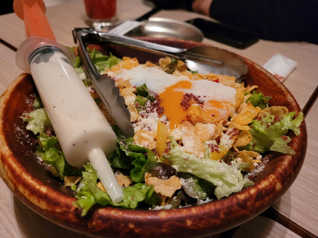 Caesar salad with dressing in a syringe